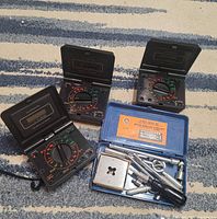 Three Micronta multimeters open beside blue socket set