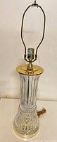 Full front view of brass and crystal table lamp with harp, cord visible