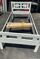 Overall view of assembled white KRITTER bed frame with bundled slats inside