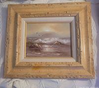 Full view of framed seascape painting showing frame and image