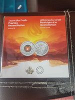 Front of sealed package showing two views of medal and bilingual text
