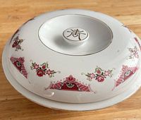 Top view of porcelain casserole lid showing floral band, longevity character finial