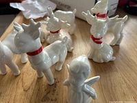 All seven white ceramic deer figurines on tabletop