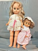 Both dolls side by side showing relative sizes and outfits
