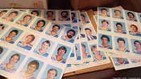 Stack of multiple uncut Oilers player photo sheets on table