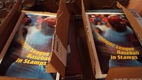 Boxes containing stacked booklets labeled Major League Baseball in Stamps