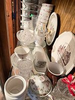Shelf view showing china cups, saucers, crystal dishes, decorative plates