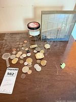 Coins, watches, money clip, pendant, magnifier, coin sorter bank on tabletop