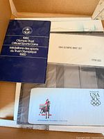 All three packaged items: 1980 medallion booklet, 1984 Olympic Mint Set, USA 30c aerogramme