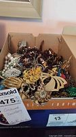 Box containing assorted costume jewelry pieces
