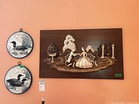 Full view showing bas-relief plaque and two loon hoops on wall