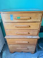 Front view of light wood secretary dresser showing four drawers and overall wear