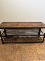 Front view of shoe rack bench showing wood top and two mesh shelves