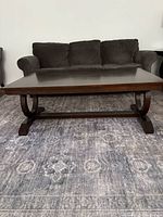 Front view of dark wood coffee table against sofa