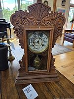 Front view showing entire carved oak mantel clock