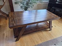 full view of wooden coffee table showing top and shelf