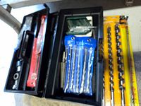 Overall view of trays with drill bits and yellow-packaged auger bits