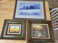 All three framed artworks laid on table