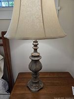 Full view of lamp with shade on wooden table