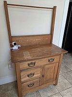Full view of oak washstand showing drawers, cabinet door, backsplash, towel bar