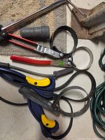 Group of five strap oil filter wrenches stacked together