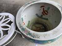 Large floral ceramic fishbowl planter and white metal plant stand