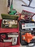 Overall view of lot showing belt sander, jigsaw, Skil case, winch and orange sander pads