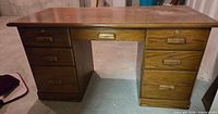 Front view showing seven drawers and oak finish