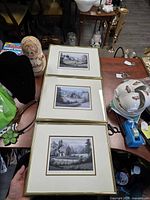 Three framed prints stacked showing overall view of lot