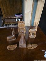 All six carved wood pieces displayed on table