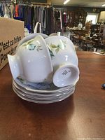 Four teacups stacked on saucers showing underside marks