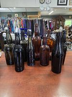 Front view of all ten embossed glass bottles in assorted colours and sizes