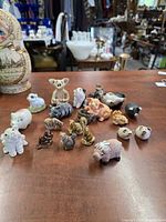 Full group of 18 ceramic and porcelain animal figurines on tabletop