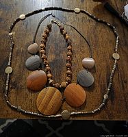 All three necklaces laid flat showing design and materials