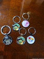 Front view of six keychains displaying artwork