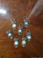 Front view showing seven owl keychains with coloured cabochons