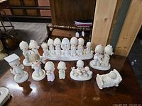 Group overview of approximately 20 Precious Moments figurines on tabletop