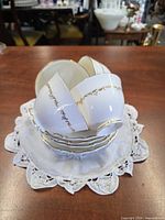Stacked teacups and saucers showing pattern and gold trim
