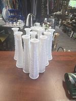 Front angled view showing all ten matching white milk glass vases together