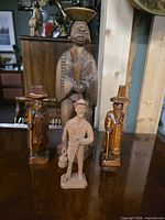Front view of all four carved wood figurines
