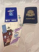 Lot overview showing two passports, two tickets, metal souvenir spoon