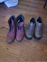 Timberland burgundy boots beside Merrell brown slip-on safety shoes