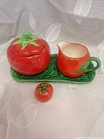 Full condiment set showing sugar bowl with lid, creamer, salt shaker and tray