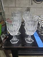 Front angle of all eight Fostoria Stratten crystal glasses showing pattern and size difference