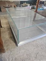 front corner view of glass display case showing glass panels and aluminum base