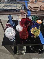 Group of eight assorted small vases on table