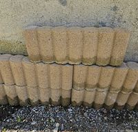 Close view of scalloped tan concrete edgers stacked
