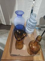 Five glass pieces grouped in tray showing colors and forms