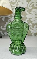 Front view of green glass eagle decanter showing overall form and texture