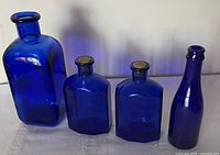 Front view of all four cobalt blue bottles standing